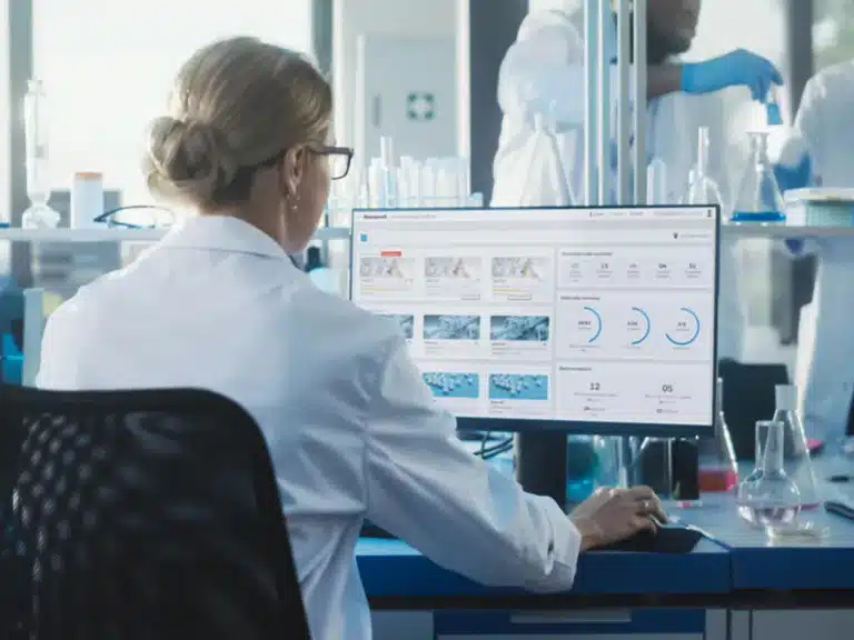 Over the shoulder of a lab worker using a computer to access Honeywell Batch Historian